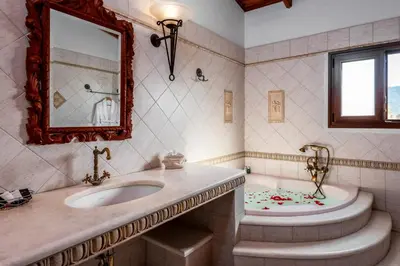 a bathroom with a sink and a tub and a mirror at Prestige Residence Rhodes in Ialyssos