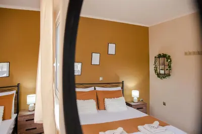 a bedroom with a bed with orange walls at Electi Apartments Charaki in Haraki