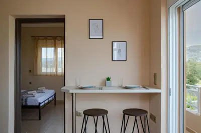 a kitchen with two stools and a counter in a room at Electi Apartments Charaki in Haraki