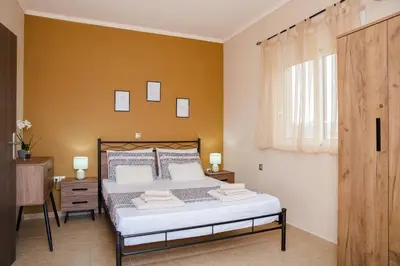 a bedroom with a bed and a yellow wall at Electi Apartments Charaki in Haraki