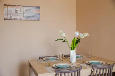 a table with plates and a vase of flowers on it at Electi Apartments Charaki in Haraki