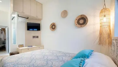 a bedroom with a bed with blue pillows on it at Antigone Traditional House in Koskinou