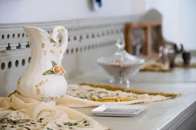 a table topped with a vase and a plate of food at Antigone Traditional House in Koskinou