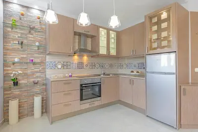 a kitchen with wooden cabinets and a white refrigerator at 4. Sea view luxury suite for 4 in Rhodes centre! in Rhodes Town