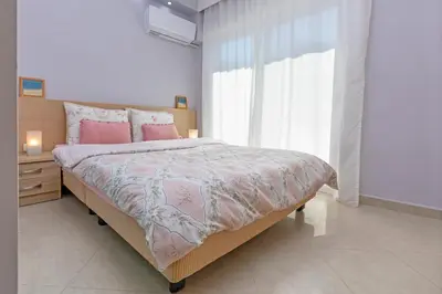 a bedroom with a bed with pink pillows and a window at 4. Sea view luxury suite for 4 in Rhodes centre! in Rhodes Town