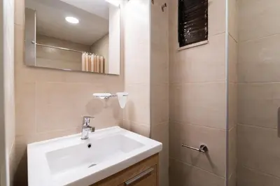 a bathroom with a sink and a mirror at Studio Amarantios in Rhodes Town