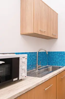 a kitchen with a sink and a microwave at Studio Amarantios in Rhodes Town