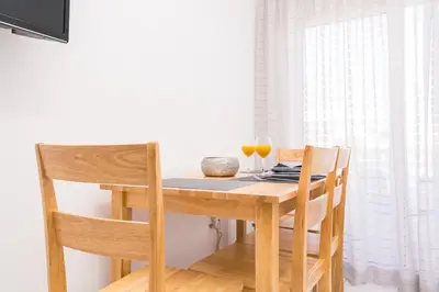 a wooden table with two glasses of orange juice on it at Studio Amarantios in Rhodes Town