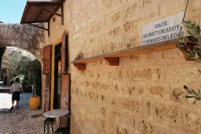a man is standing outside of a brick building at Natasha's Nest in Rhodes Town