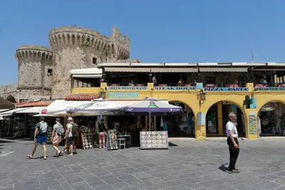a group of people walking around a market with a building at Natasha's Nest in Rhodes Town