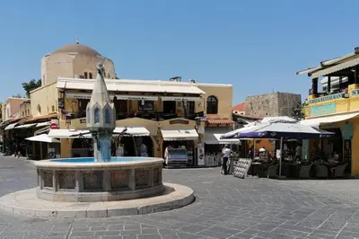 a fountain in the middle of a street with buildings at Natasha's Nest in Rhodes Town