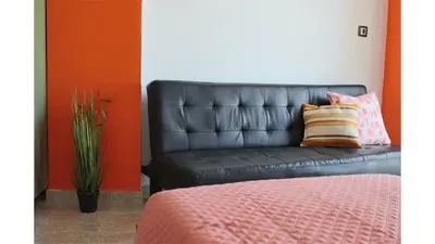a black leather couch with two pillows in a room at Planet View in Faliraki