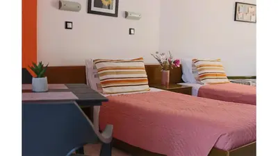 a room with two beds and a table at Planet View in Faliraki