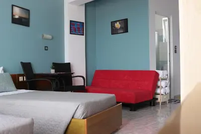 a bedroom with a bed and a red couch at Planet View in Faliraki