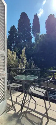 a table and a bench on a patio with trees at CASA DE MIKEL 2 in Rhodes Town