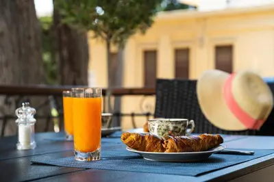 a table with a plate of food and a glass of orange juice at La Casa di Efi in Rhodes Town
