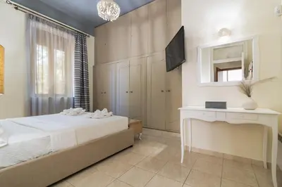 a bedroom with a bed and a desk and a television at La Casa di Efi in Rhodes Town