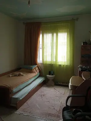 a bedroom with a bed and a window with green curtains at Home sweet home in Rhodes Town