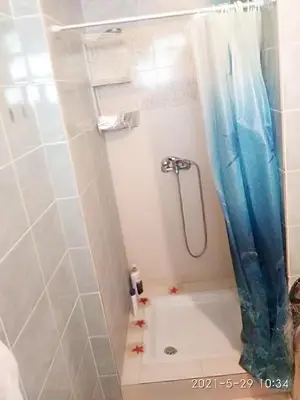 a shower with a blue shower curtain in a bathroom at Home sweet home in Rhodes Town