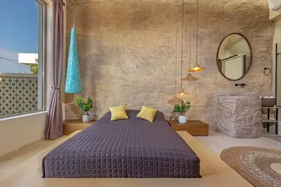 a bedroom with a large bed and a mirror at Gaia Blue Villa in Kolimbia