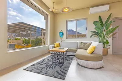a living room with a couch and a table at Gaia Blue Villa in Kolimbia