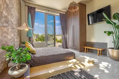 a bedroom with a bed and a large window at Gaia Blue Villa in Kolimbia
