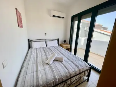 a bedroom with a bed with two pillows on it at Kelly's Beach House 1 in Gennadi