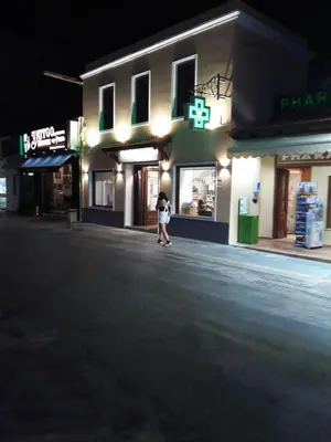 a woman standing outside of a store at night at AS SUITES ROOM 14 in Rhodes Town