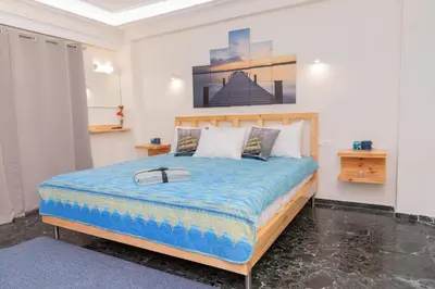 a bedroom with a large bed with a blue comforter at AS SUITES ROOM 14 in Rhodes Town