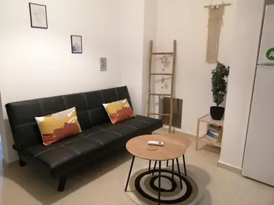 a living room with a black couch and a table at Sable Blanc Apartments in Ixia