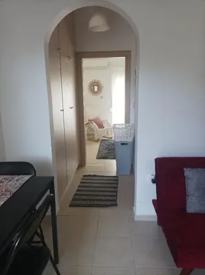a hallway with a living room with a red couch at Sable Blanc Apartments in Ixia
