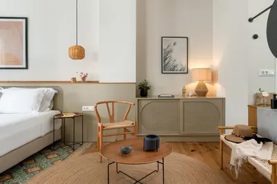 a bedroom with a bed and a tv and a chair at Casa Natura in Rhodes Town
