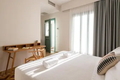 a bedroom with a bed and a desk and a window at Casa Natura in Rhodes Town