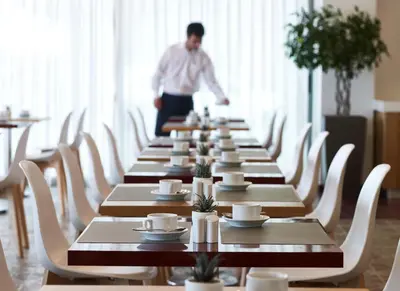 a man standing in front of a long row of tables at Aquarium View Hotel in Rhodes Town