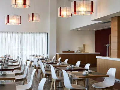 a dining room with wooden tables and white chairs at Aquarium View Hotel in Rhodes Town