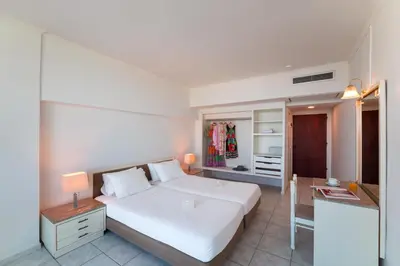 a bedroom with a large white bed and a mirror at Aquarium View Hotel in Rhodes Town