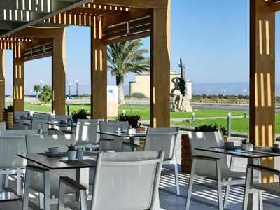 a restaurant with white tables and white chairs at Aquarium View Hotel in Rhodes Town