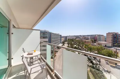 a balcony with a chair and a view of a city at Aquarium View Hotel in Rhodes Town
