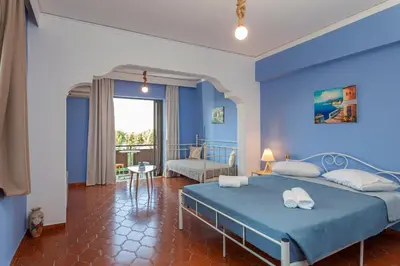 a blue bedroom with a bed and a chair at CHAMBRE BLEUE in Ialyssos