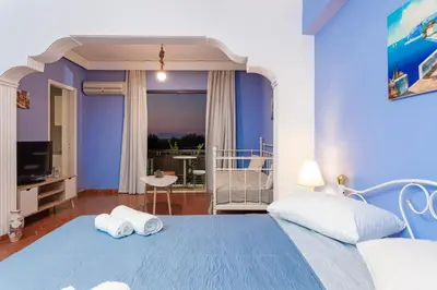a bedroom with a blue bed with two towels at CHAMBRE BLEUE in Ialyssos