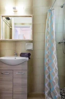 a bathroom with a sink and a mirror at CHAMBRE BLEUE in Ialyssos