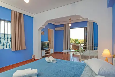 a blue bedroom with a bed and a balcony at CHAMBRE BLEUE in Ialyssos