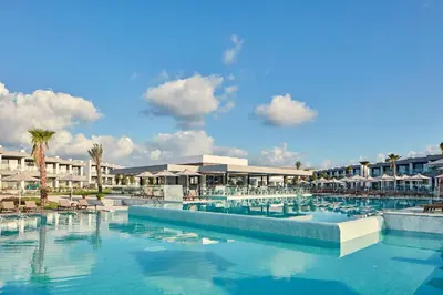 a swimming pool with chairs and umbrellas in a resort at Atlantica Dreams Resort in Gennadi