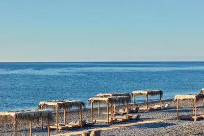 a group of straw umbrellas on the beach at Atlantica Dreams Resort in Gennadi