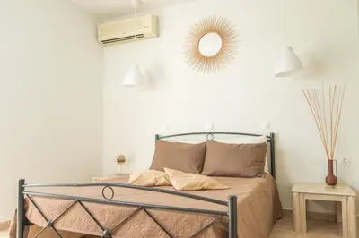 a bedroom with a bed and a mirror on the wall at Kampus Living Luxury Complex in Faliraki