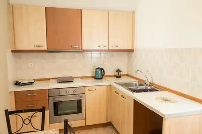 a kitchen with wooden cabinets and a stove and a sink at Kampus Living Luxury Complex in Faliraki