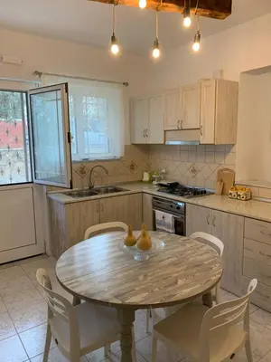 a kitchen with a wooden table with chairs and a table at Kampus Living Luxury Complex in Faliraki