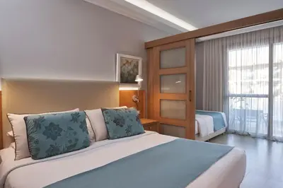 a bedroom with a large bed and a large window at Atlantica Holiday Village Rhodes in Kolimbia