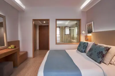 a bedroom with a large bed and a window at Atlantica Holiday Village Rhodes in Kolimbia