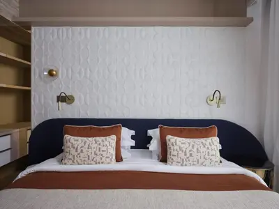 a bedroom with a large bed with a blue headboard at Atlantica Holiday Village Rhodes in Kolimbia